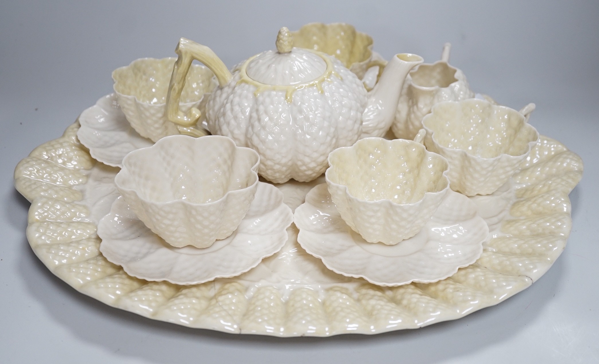 A Belleek porcelain teaset comprising tray, teapot, milk jug, sugar bowl, four cups and four saucers